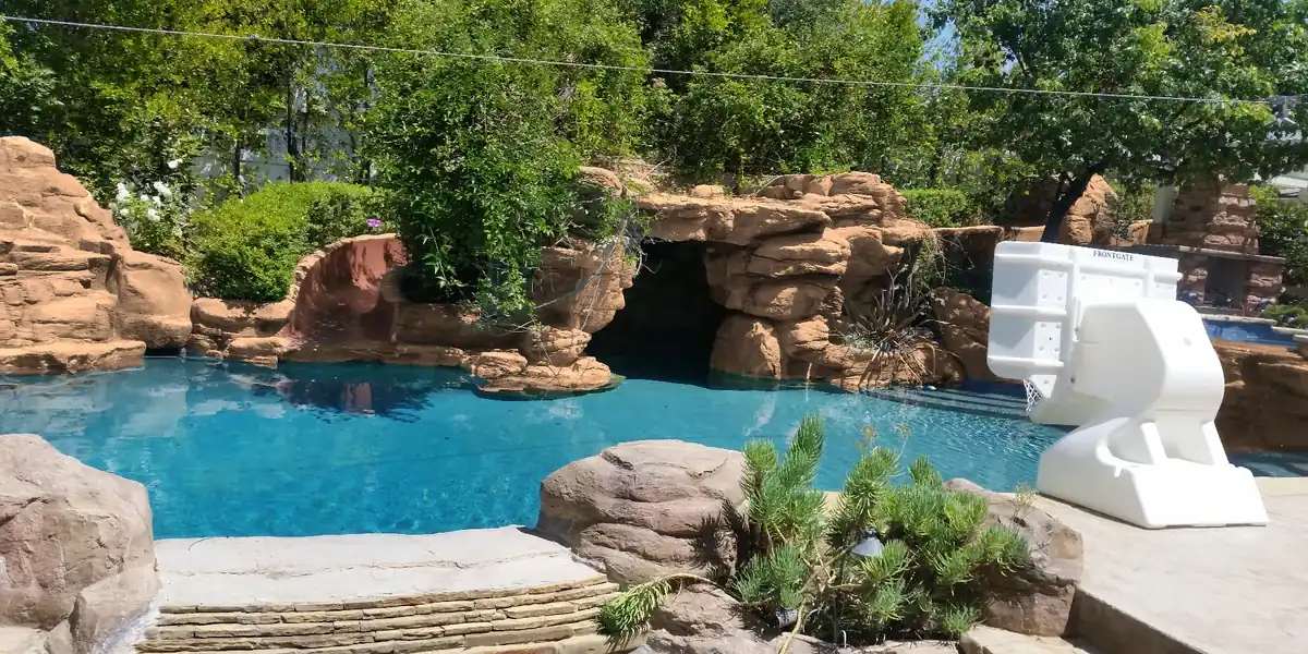 L-shaped family gunite pool with travertine deck and shallow play area in Encino