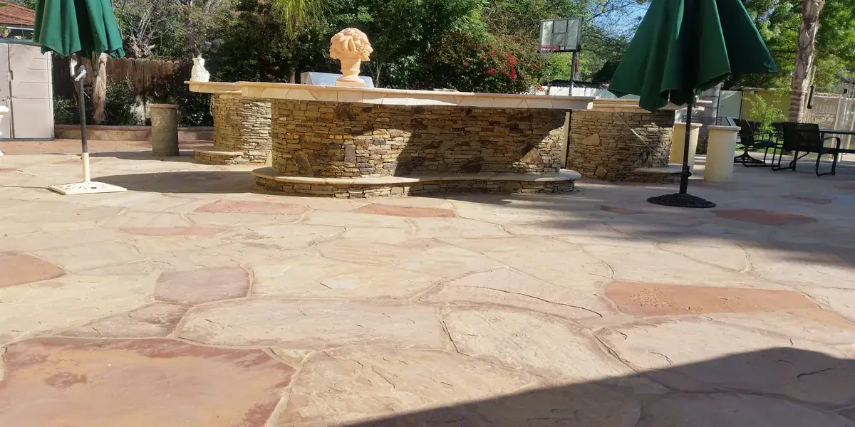 Outdoor kitchen with stone counters and flagstone deck in Northridge